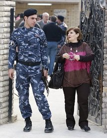 A parishoner passing an Iraqi security officer, outside the Our Lady of the Sacred Heart Chaldean Church A parishoner passing an Iraqi security officer, outside the Our Lady of the Sacred Heart Chaldean Church