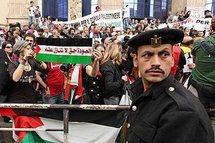 A policeman in front of foreign activists as they protest outside the Egyptian Press Syndicate A policeman in front of foreign activists as they protest outside the Egyptian Press Syndicate