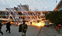 Palestinian civilians run for cover as a white phosphorous shell rains down over a UN school in Beit Lahiain, during the Israeli offensive in 2009 (AFP/File/Mohammed Abed)