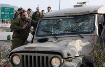 Israeli soldiers inspect a damaged army jeep after a stabbing attack