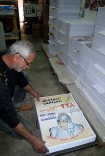 An Iraqi man checks election campaign posters