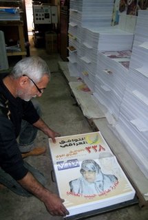 An Iraqi man checks election campaign posters An Iraqi man checks election campaign posters