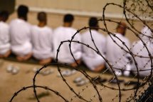 Detainees kneel during early morning Islamic prayer