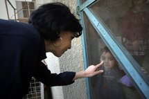 Rachida Dati plays with an orphaned Iraqi girl during a visit to St. Raphael hospital