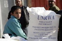 A Palestinian boy sits next to food aid distributed from the United Nations Relief and Works Agency A Palestinian boy sits next to food aid distributed from the United Nations Relief and Works Agency