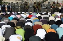 Israeli police stand guard as Palestinian Muslims perform Friday prayer outside Jerusalem's Old City