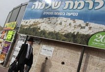 An Israeli ultra-orthodox Jewish man walks past a sign carrying the image of the east Jerusalem settlement of Ramat Shlomo on March 11. (AFP/File/Gali Tibbon) An Israeli ultra-orthodox Jewish man walks past a sign carrying the image of the east Jerusalem settlement of Ramat Shlomo on March 11. (AFP/File/Gali Tibbon)