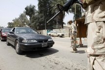 Iraqi soldiers stop vehicles at a checkpoint in Baghdad.