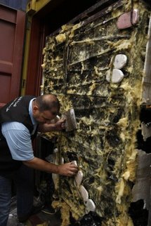 A Lebanese custom official collects packs of hashish confiscated from a container. A Lebanese custom official collects packs of hashish confiscated from a container.