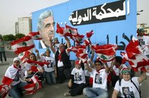 Lebanese people in front of a banner with a portrait of Rafiq Hariri.