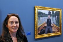 Exhibition curator Marina Ferretti Bocquillon poses in front of the painting 'The Boating Party'. Exhibition curator Marina Ferretti Bocquillon poses in front of the painting 'The Boating Party'.