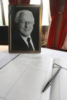 A photograph of the late Wolfgang Wagner is placed next to a condolence book. A photograph of the late Wolfgang Wagner is placed next to a condolence book.