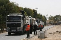 Hamas policemen inspect trucks carrying clothes and shoes as they pass the Kerem Shalom crossing on 4th April.  (AFP/File/Said Khatib)