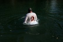 A Christian pilgrim walks in the waters of the Jordan river in 2009.