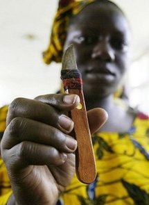 A woman who performs genital cutting shows a knife she uses during a gathering to denounce circumcision in 2005, in Abidjan.