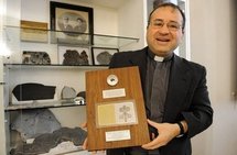 Jesuit priest Jose Gabriel Funes, director of the Vatican's astronomic observatory, poses with a lunar's stone in April 2010.