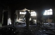 Israeli soldiers inspect a burnt mosque in the northern West Bank town of Lubban ash-Sharqiya, south of Nablus