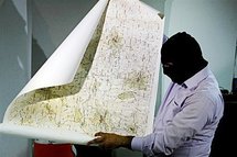 A Lebanese security officer holds a map found with arrested Lebanese nationals accused of spying for Israel in 2009.