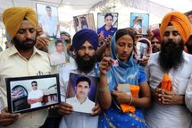 In Amritsar, relatives hold photographs of Indians sentenced to death for killing a Pakistani in the UAE.