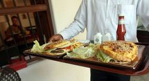 A waiter serves camel burgers at the Local House restaurant.