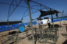 UNRWA staff members examine the damage done to the summer camp.