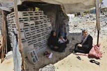 A Palestinian family sits in a makeshift shelter after its home was demolished by Hamas security forces in Rafah on 19th May.