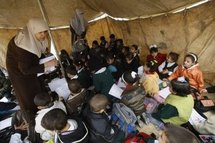 Palestinian schoolchildren attend a lesson under a tent in the yard of their Islamic school, which was destroyed during Israel's devastating three-week offensive, in Rafah, in the southern Gaza strip, in 2009.