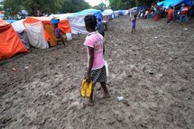 A girl walks through the mud-clogged streets of a tent city in Port-au-Prince.