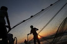Palestinian fishermen prepare their nets on the beach in Deir al-Balah in the Gaza strip. Palestinian fishermen prepare their nets on the beach in Deir al-Balah in the Gaza strip.