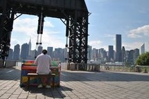 A man plays a public piano as part of the 'Play Me, I'm Yours' art display in New York.