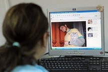 A woman looks at a Facebook page showing a picture of Khaled Said. A woman looks at a Facebook page showing a picture of Khaled Said.