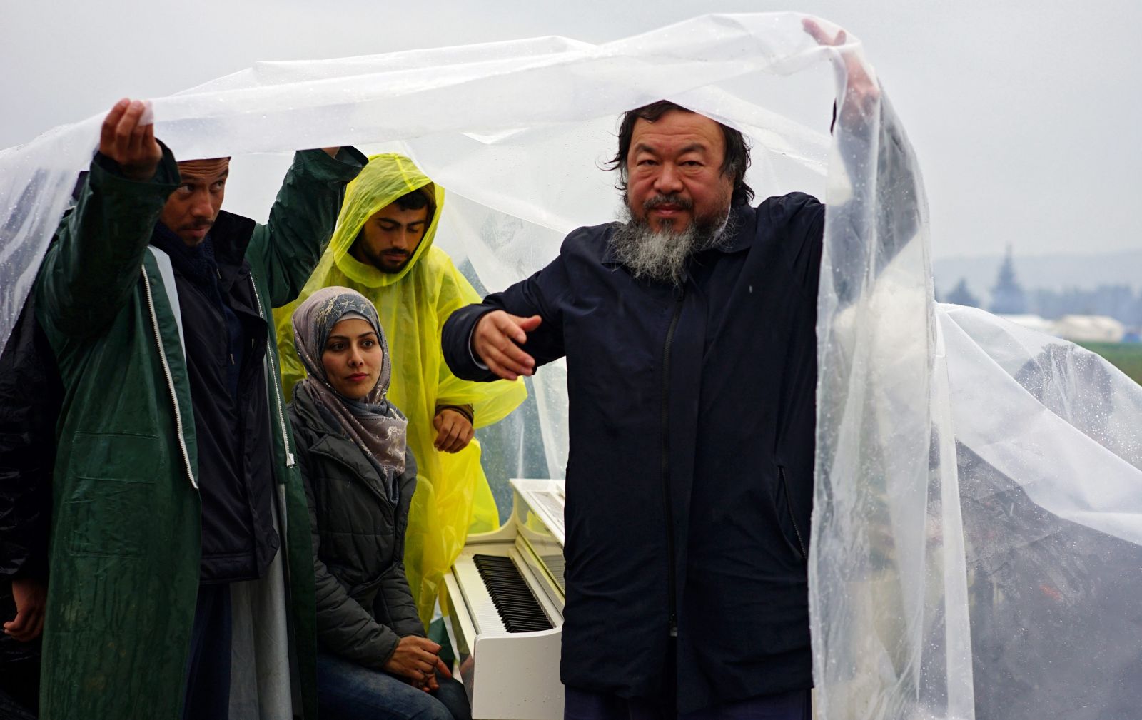Ai Weiwei brings white grand piano to muddy refugee field Ai Weiwei brings white grand piano to muddy refugee field