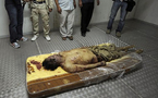 Kadhafi buried in secret, NATO asked to stay on